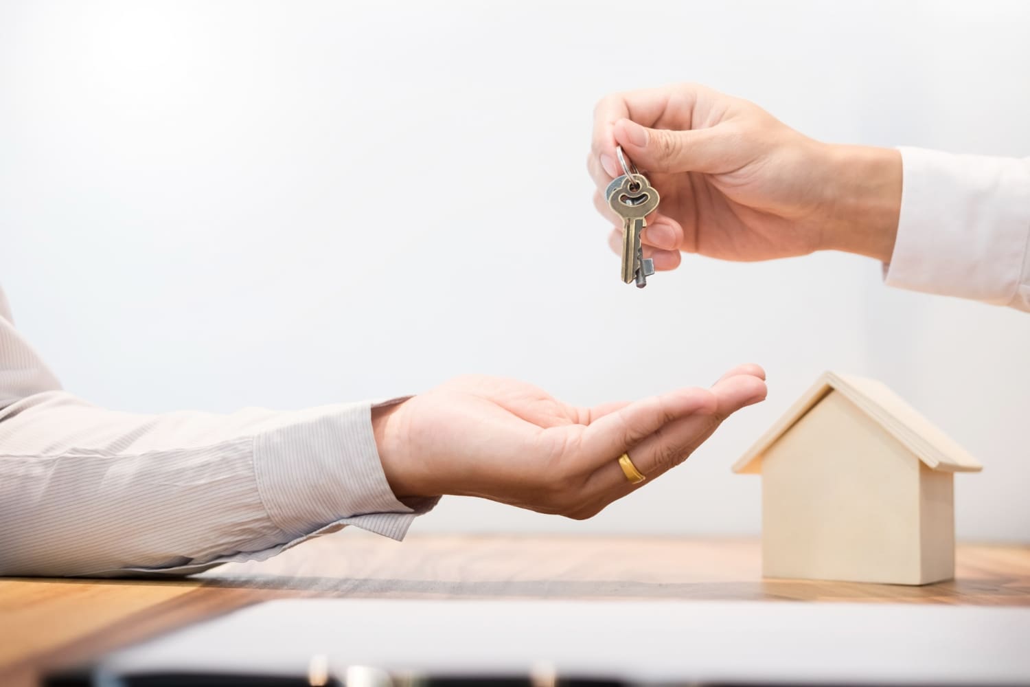 Estate agent in suit sitting in an office desk Handing over of house keys