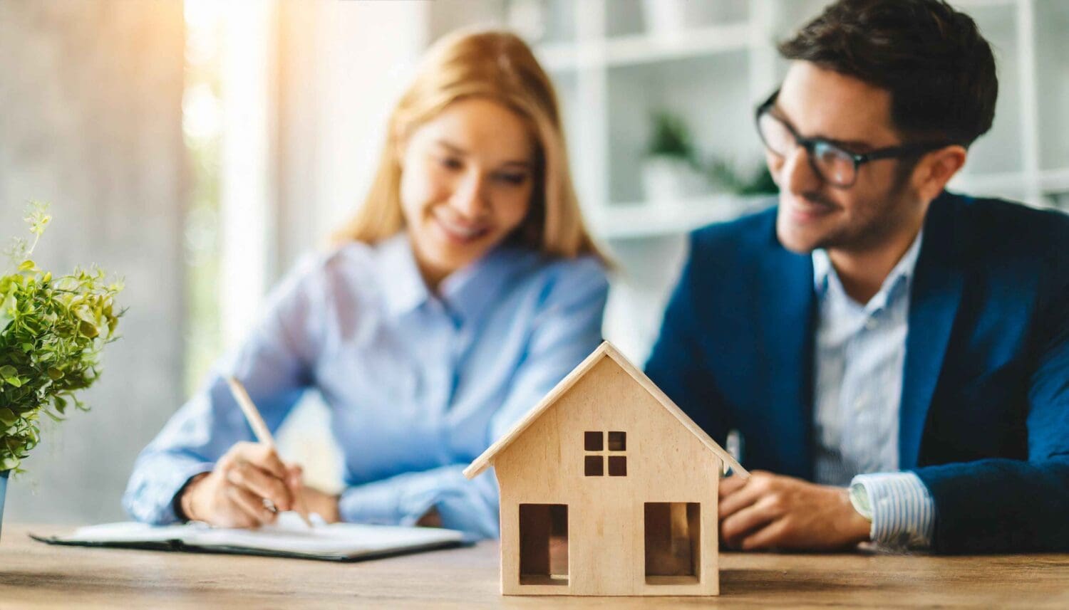 Wooden house model symbolizing dreams depicts a happy couple