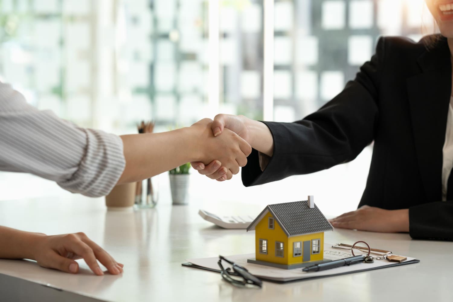 broker and customer shaking hands after signing a contract